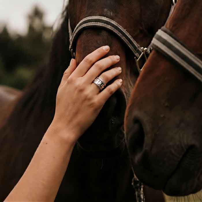 Horseshoe Band Ring Sterling Silver shown on horse lover's hand on horse