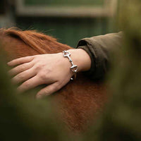 Bangle Snaffle Bit Bracelet Sterling Silver on wirst of hand patting a horse