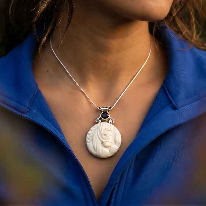 Cara carved horse head pendant necklace with topaz shown on person