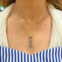 Framed pair of horses necklace sterling silver on woman