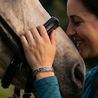 Galloping horses cuff bracelet in sterling silver shown on horse lovers wrist