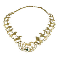 A gold-toned statement necklace featuring multiple horse silhouettes and a central horse motif with a small green stone accent, displayed on a plain white background.