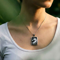 A sterling silver necklace featuring a detailed pendant of a horse's head with a flowing mane, set against a black background.shown on a horse lover