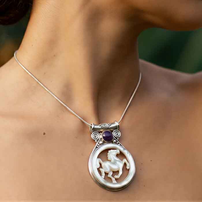Carved Mother of Pearl Dancing Horse Pendant set in sterling silver with amehyst accent shown on person