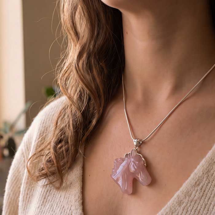 Rose quartz carved horse head pendant necklace with sterling silver bail shown on neck of horse lover