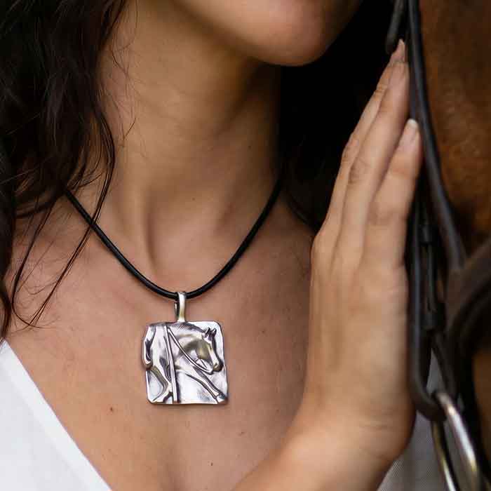 Austin western reining horse pendant necklace in sterling silver on person with horse