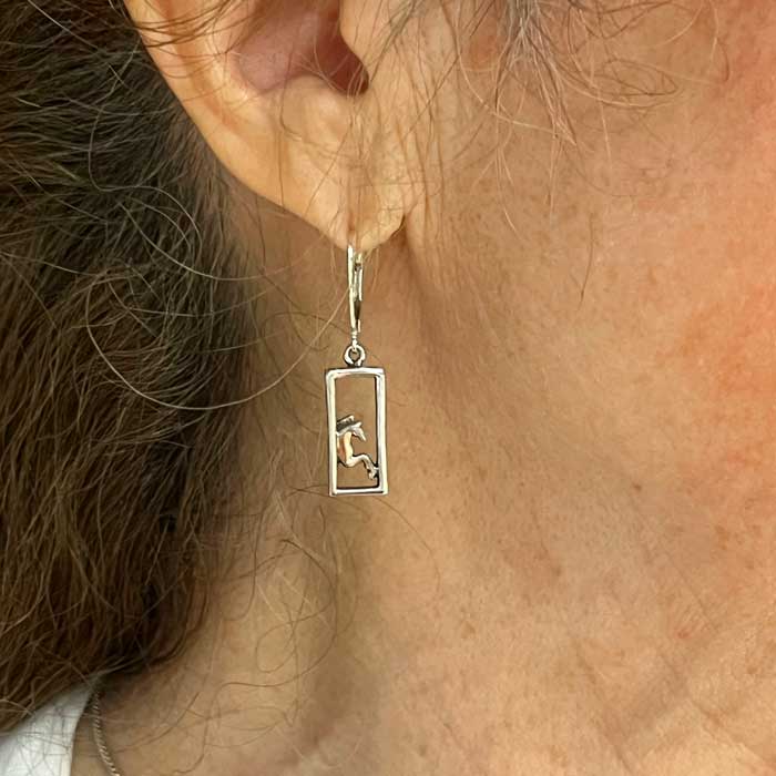 framed pair of horses dangle earring on ear
