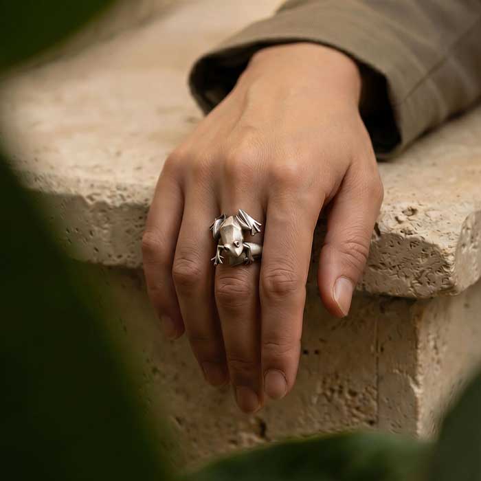 Frog Ring in Sterling Silver with ruby red eyes shown on womans hand