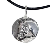 The image shows a sterling silver pendant necklace featuring a raised relief depiction of a classic Hunter Horse with a snaffle bit bridle and braided mane. The pendant is circular and has an omega-shaped bail at the top.
