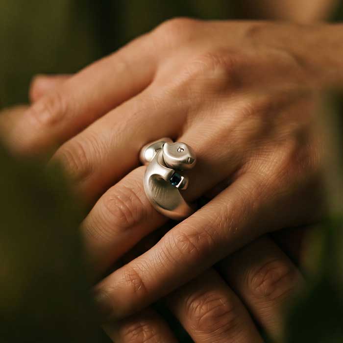 Otter Ring in Sterling Silver close up view of face and stone shown on hand