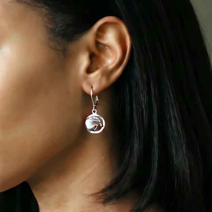 A pair of sterling silver dangle earrings featuring a silhouette of a jumping horse with its knees tucked up shown on horse lover